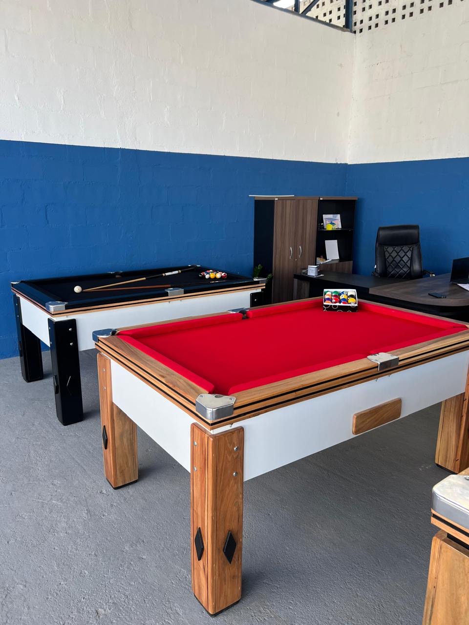 Mesas de sinuca com tecidos vermelho e preto no showroom